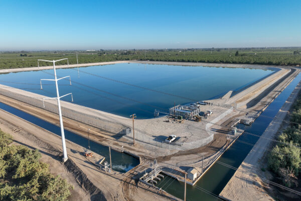 Aerial photo of a small reservoir surrounded by canals and orchards.