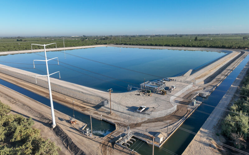 Aerial photo of a small reservoir surrounded by canals and orchards.