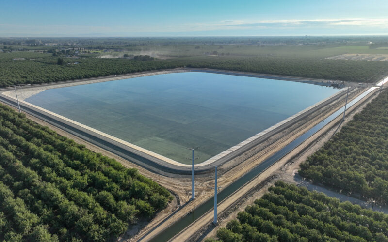 Aerial photo of a small reservoir surrounded by canals and orchards.